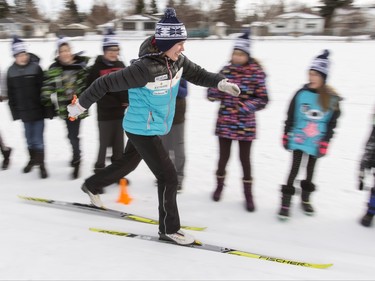 Olympic silver medallist Sara Renner skis past kids at Mount View School in Calgary, Alta., on Tuesday, Jan. 26, 2016. The Calgary Fire Department and Calgary Police Service, along with a pair of Olympians, went head-to-head in a relay race for an announcement by AltaGas to support Cross Country Ski de Fond Canada's Ski at School program for the next three years. Lyle Aspinall/Postmedia Network