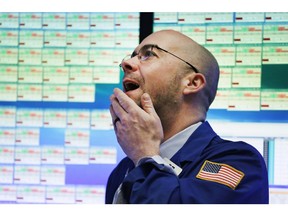 Trader Jarret Johnson follows stock prices at the New York Stock Exchange, Friday, Jan. 22, 2016.
