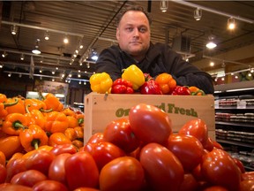 Jason Wiebe, president of Chongos's Market in the Crossroads Market poses with some of the imported produce that has recently seen large price increases in Calgary, on Friday January 22, 2016.