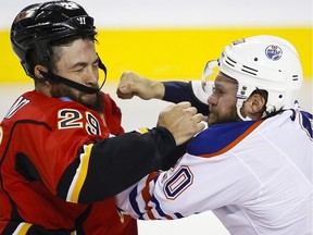 Edmonton Oliers' Luke Gazdic, right, exchanges blows with Calgary Flames' Deryk Engelland during first period NHL hockey action in Calgary on Saturday, Oct. 17, 2015.