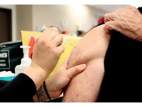 A elderly man gets his influenza immunization shot at the flu clinic in Northgate in Calgary on October 21, 2015.