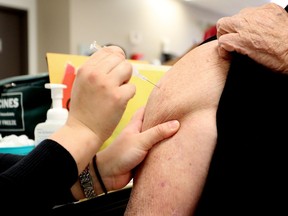 An elderly man gets his influenza immunization shot