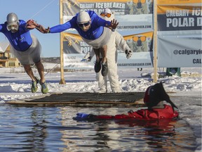 Organizers Ross Weaver, right, and Bernie Potvin, take the first dip at the 7th annual Calgary Ice Breaker Polar Dip in conjunction with SA Foundation and raising funds for the fight against human trafficking at the Elbow Valley Resident's Club in Calgary, on Jan. 1, 2016.