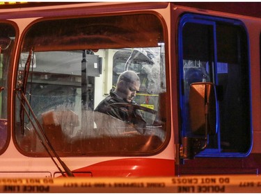 Police inside a City Transit bus hit by gunfire. Police breach a home nearby after shots were fired toward police at 10 st and 78 ave NW in Calgary, Ab., on Sunday January 24, 2016. Mike Drew/Postmedia Network