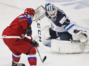 Calgary Hitmen forward Radel Fazleev of Russia, left, tries to score on Finnish goalkeeper Kaapo Kahkonen during last week's championship match. Fazleev returned to Hitmen practice on Tuesday after helping Russia win a silver medal.