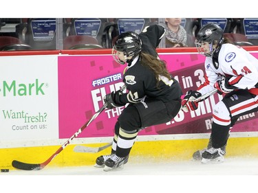 Northern Capitals forward Hunter Mosher, right, chased Rocky Mountain Raiders defenceman Catherine Longchamps into the corner during the Mac's AAA Midget female final at the Scotiabank Saddledome on January 1, 2016. The Capitals defeated the Raiders 5-1 to take the 2015 title.