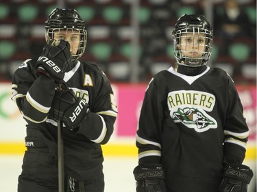 Members of the Rocky Mountain Raiders stood watching as the Northern Capitals were awarded the trophy following the Mac's AAA Midget female final at the Scotiabank Saddledome on January 1, 2016. The Capitals defeated the Raiders 5-1 to take the 2015 title.