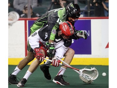 Reilly O'Connor of the Calgary Roughnecks is tackled by Jeff Cornwall of the Saskatchewan Rush in the Rush Saturday during their home opener.