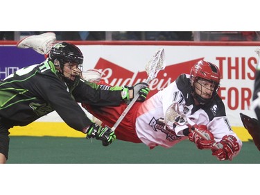 Curtis Dickson of the Calgary Roughnecks lunges for the Saskatchewan Rush net ahead of Adrian Sorichetti during their home opener Saturday night January 2, 2016 at the Saddledome.