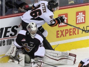 Calgary Hitmen Andrew Fyten collides with Vancouver Giants goalie Ryan Kubic outside the crease at the Scotiabank Saddledome in Calgary, on January 8, 2016.
