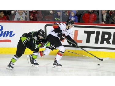 Hitmen Matteo Gennaro, 21, tries to keep the puck away from Oil Kings Luke Bertolucci, 11, as the Calgary Hitmen played host to the Edmonton Oil Kings on Saturday, January 16, 2016 at the Saddledome.