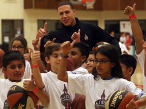 Former NBA star Mike Bibby is given the thumbs up by kids at the Saddletowne YMCA during a fan fest event, on January 8, 2016.