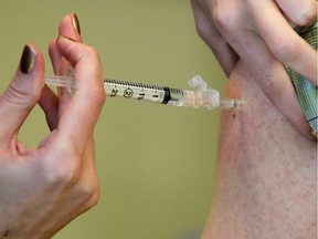 The flu vaccine is administered at an Alberta Health Services immunization clinic  in Sundance.