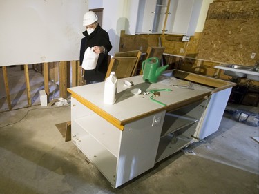 Leonid Oukrainski of Alberta Infrastructure eyes a jug of bleach inside a flood-damaged home on Riverdale Ave SW in Calgary, Alta., on Friday, Jan. 29, 2016. The province showed media around two of the 17 homes purchased by the government after the 2013 flood that are slated for demolition as a lead-up to a community discussion about what to do with the lots once they're vacant. Lyle Aspinall/Postmedia Network
