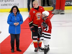 Christine McIver lines up Tyler Oakenfold of the AAA midget Calgary Flames and Eric Zukowski to do the ceremonial puck drop.