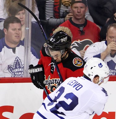 Calgary Flames Michael Frolik , left, gets a stick in the face from Toronto Maple Leafs Josh Leivo goalie during first period action in NHL hockey action at the Scotiabank Saddledome in Calgary, Alta. on Tuesday February 9, 2016. Leah Hennel/Postmedia