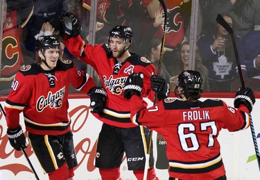 Calgary Flames Markus Granlund, left, celebrates his goal on Toronto Maple with teammates TJ Brodie, MIDDLE AND Michael Frolik during first period action in NHL hockey action at the Scotiabank Saddledome in Calgary, Alta. on Tuesday February 9, 2016. Leah Hennel/Postmedia