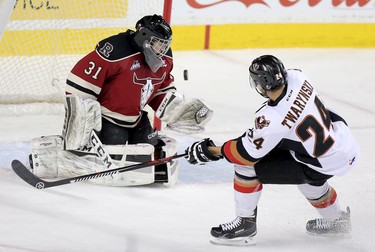 Calgary Hitmen Carsen Twarynski, right, shoots on Red Deer Rebels goalie Rylan Toth in WHL action at the Scotiabank Saddledome in Calgary, Alberta, on Friday, February 12, 2016. Leah Hennel/Postmedia