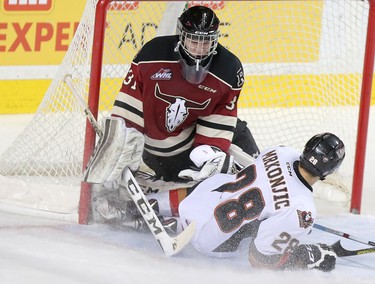 Calgary Hitmen Tyler Mrkonjic crashes into Red Deer Rebels netminder Rylan Toth in WHL action at the Scotiabank Saddledome in Calgary, Alberta, on Friday, February 12, 2016. Leah Hennel/Postmedia