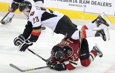 Calgary Hitmen Taylor Sanheim collides with Red Deer Rebels Brandon Hagel in WHL action at the Scotiabank Saddledome in Calgary, Alberta, on Friday, February 12, 2016. Leah Hennel/Postmedia