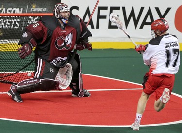 Calgary Roughnecks Curtis Dickson, right, scores on Colorado Mammoth netminder Dillon Ward during game action at the Scotiabank Saddledome in Calgary, Alta. on Saturday February 13, 2016. Leah Hennel/Postmedia