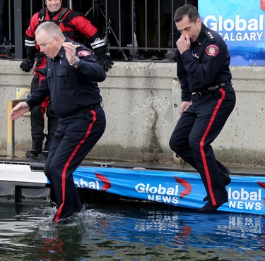 Calgary police chief Roger Chaffin, left, and Deputy Chief Trevor Daroux take a cold dip in Arbour Lake during Polar Plunge in support for Special Olympics Albarta in Calgary, Ab., on Sunday February 28, 2016. Leah Hennel/Postmedia
