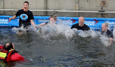 Calgary Police recruit Karmen Brown, left, and other members of the 214 recruit class jump into Arbour Lake during Polar Plunge in support for Special Olympics Albarta in Calgary, Ab., on Sunday February 28, 2016. Leah Hennel/Postmedia
