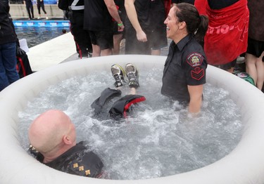 Scott Boyd Inspector in charge of learning centre, left, and Jennifer Lessard Staff Sgt., learning centre warm up after jumping in Arbour Lake during  Polar Plunge in support for Special Olympics Albarta in Calgary, Ab., on Sunday February 28, 2016. Leah Hennel/Postmedia