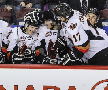 Calgary Hitmen Dawson Martin, left, is congratulated on the bench by teammates Mark Kastelic and Jordy Stallard after scoring his first goal - which turned out to be the game winner - against Lethbridge Hurricanes goalie Jayden Sittler in WHL action at the Scotiabank Saddledome in Calgary, Alberta, on Saturday, February 20, 2016. The Hitmen beat the Hurricanes 3-2. Mike Drew/Postmedia