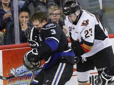 Victoria Royals Ryan Gagnon grimaces after having his head slammed into the plexiglass by Calgary Hitmen Taylor Sanheim in WHL action at the Scotiabank Saddledome in Calgary, Alberta, on Friday, February 26, 2016. Mike Drew/Postmedia