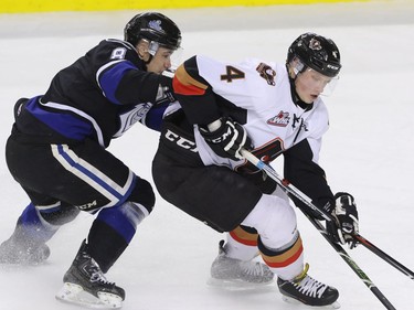 Victoria Royals Ethan Price tries to slow down  Calgary Hitmen Micheal Zipp in WHL action at the Scotiabank Saddledome in Calgary, Alberta, on Friday, February 26, 2016. Mike Drew/Postmedia