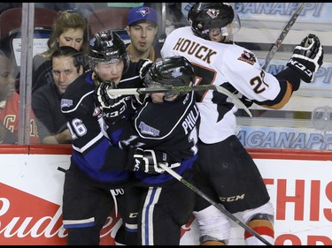 Calgary Hitmen Jackson Houck slams into Victoria Royals Alex Forsberg and Matthew Phillips in WHL action at the Scotiabank Saddledome in Calgary, Alberta, on Friday, February 26, 2016. Mike Drew/Postmedia