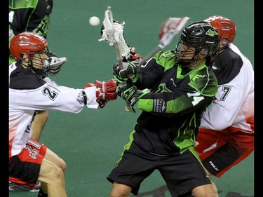 Calgary Roughnecks Karsen Leung, left, and Tyler Burton battle for the ball with Saskatchewan Rush Jeremy Thompson in NLL action at the Scotiabank Saddledome in Calgary, Alta. on Sunday February 28, 2016. The Roughnecks lost in overtime 12-11. Mike Drew/Postmedia