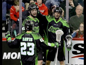 Saskatchewan Rush Jarrett Davis, Dan Taylor and Zak Greer celebrate their overtime win against the Calgary Roughnecks in NLL action at the Scotiabank Saddledome in Calgary, Alta. on Sunday February 28, 2016. The Roughnecks lost in overtime 12-11. Mike Drew/Postmedia