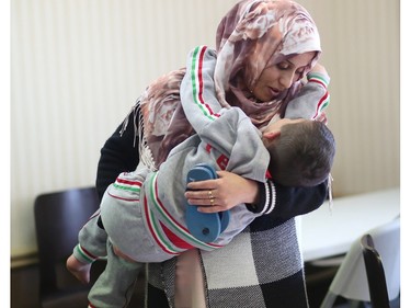 A Syrian refugee women and her son  enjoy some time together after eating at a hotel they are living at in Calgary, Ab., on Tuesday February 23, 2016.