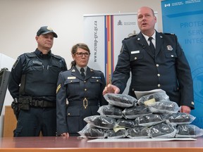 Border Services officer Cody Uytterhagen, left, RCMP Cpl. Sharon Franks listen to CBSA Superintendent Darryl Anderson as he makes a statement regarding the seizure of 14.5kg of suspected methamphetamine in Southern, Alberta.   At the news conference in Raymond, Alberta, Friday, February 5, 2016,