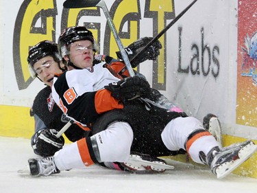 The Medicine Hat Tigers' Mason Shaw and Calgary Hitmen Matteo Gennaro collide behind the net during WHL action at the Scotiabank Saddledome on Sunday February 21, 2016.