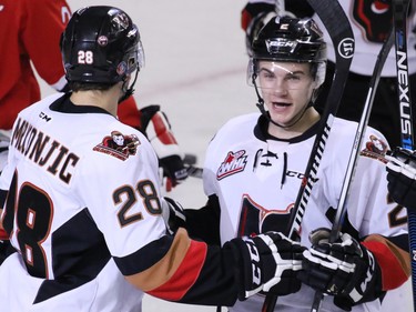 Calgary Hitmen Tyler Mrkonjic, left, congratulates Jake Bean after he scored the team's second goal on the Portland Winterhawks' during first period WHL action at the Scotiabank Saddledome on Tuesday February 23, 2016.
