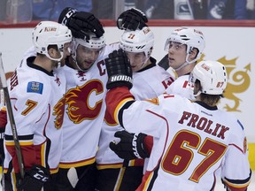 Calgary Flames' centre Mikael Backlund (11) celebrates his goal on the Vancouver Canucks with teammates during third period NHL action, in Vancouver on Saturday, Feb. 6, 2016.
