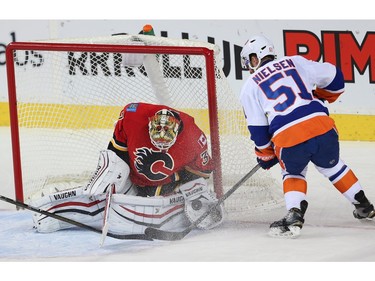 Calgary Flames Joni Ortio makes a save on a shot by Frans Nielsen of the New York Islanders during NHL hockey in Calgary, Alta., on Thursday, February 25, 2016.