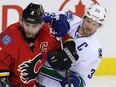 Calgary Flames Mark Giordano battles with Henrik Sedin of the Vancouver Canucks during NHL hockey in Calgary, Alta., on Friday, February 19, 2016. Al Charest/Postmedia