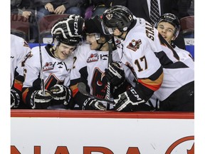 Calgary Hitmen Dawson Martin, left, is congratulated on the bench by teammates Mark Kastelic and Jordy Stallard after scoring his first goal - which turned out to be the game winner - against Lethbridge Hurricanes goalie Jayden Sittler in WHL action at the Scotiabank Saddledome.