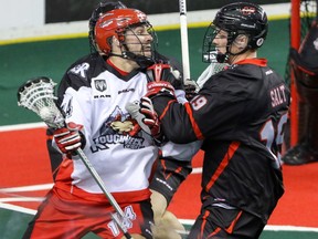 Calgary Roughnecks Wesley Berg shoves his way past Vancouver Stealth Justin Salt in NLL action at the Scotiabank Saddledome in Calgary, Alta. on Saturday January 30, 2016.