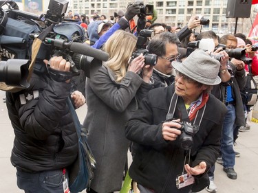 Photographer Len Chan looks at the crush of cameras behind him during a Chinese New Year celebration outside of the Chinese Cultural Centre in downtown Calgary, Alta., on Sunday, Feb. 7, 2016. The Chinese community is celebrating the Year of the Monkey. Lyle Aspinall/Postmedia Network