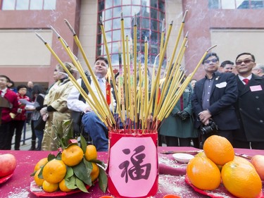 Dignitaries pose for a group photo behind incense sticks during a Chinese New Year celebration outside of the Chinese Cultural Centre in downtown Calgary, Alta., on Sunday, Feb. 7, 2016. The Chinese community is celebrating the Year of the Monkey. Lyle Aspinall/Postmedia Network