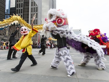 The Happy Buddha walks amid lions during a Chinese New Year celebration outside of the Chinese Cultural Centre in downtown Calgary, Alta., on Sunday, Feb. 7, 2016. The Chinese community is celebrating the Year of the Monkey. Lyle Aspinall/Postmedia Network