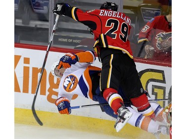 Deryk Engelland of the Calgary Flames knocks Anders Lee of the New York Islanders off his feet early in the first period behind the Flames net at the Saddledome Thursday night February 25, 2016.
