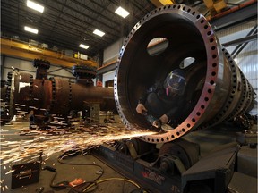 EDMONTON,  ALBERTA, OCTOBER 18, 2013: Workers grind the interior of a heat exchanger being fabricated at Altex Steel in Edmonton, Ab. on Friday Oct. 18, 2013. (photo by John Lucas/Edmonton Journal)(for a story by Gary Lamphier) Altex Industries, a fast-growing Edmonton-based metal fabrication firm that supplies the energy and petrochemical sectors, will unveil a major plant expansion on Friday