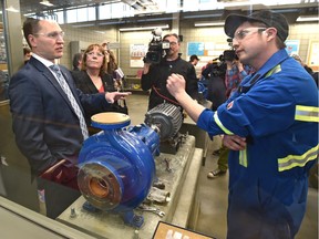 First-year millwright student Riley Turchanski speaks with Minister of Economic Development and Trade Deron Bilous and Energy Minister Marg McCuaig-Boyd before an announcement about the Alberta government plan to diversify the economy and create jobs in the petrochemical sector, at NAIT.
