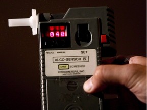 FILE PHOTO: An RCMP Constable holds a breathalyzer test in Surrey, B.C., in this September 24, 2010 photo. Statistics Canada says police reported more than 90,000 impaired driving cases in 2011, about 3,000 more than in 2010.